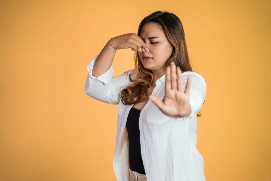 A woman blocking her nose due to smelling clear retainers