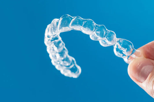 An image of a hand holding a clear retainer