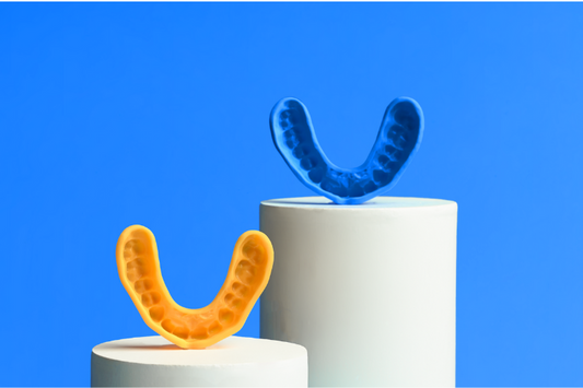 A blue and yellow custom mouthguard on a light blue background 