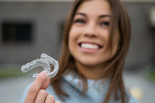 A girl is holding a dental retainer