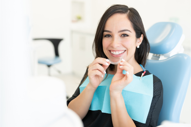 A patient at clinic holding a clear aligner tray   