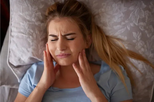 A girl feels jaw pain after waking up