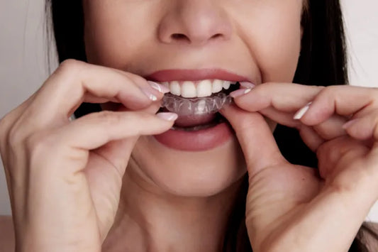 A closeup of a girl applying clear aligners.