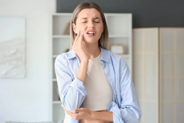 A woman suffering from tooth pain due to a cavity.