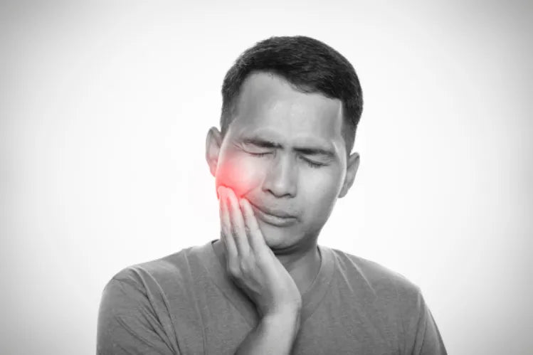 Man holding his jaw due to extreme pain.
