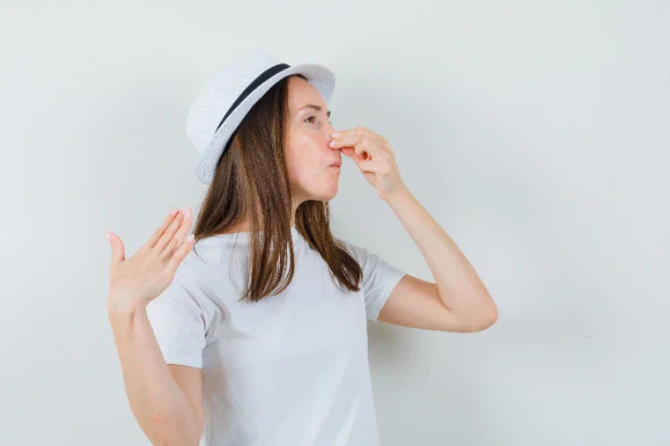 Young girl pinching her nose in disgust due to bad smell, symbolizing smelly retainers.