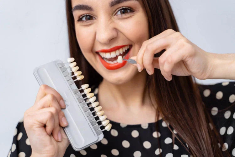 An image of a girl holding dental veneers